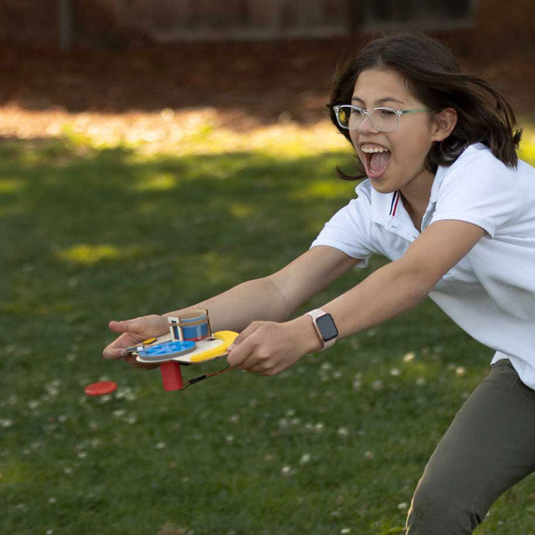 Photo of Girl Playing with the Disc Launcher Outside